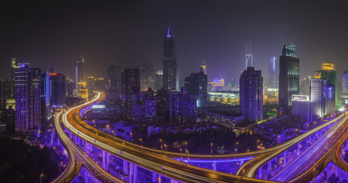 Futuristic highway crowded skyscraper cityscape illuminated at night Shanghai China